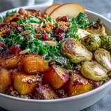 Fall Vegetable Bowl with roasted squash, Brussels sprouts, and tender kale served over hearty farro, topped with sweet apple slices.