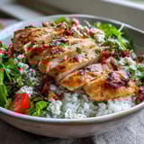 Golden sliced chicken and bright cherry tomatoes rest on rice and greens for a vibrant Sun-Dried Tomato Chicken Bowl.