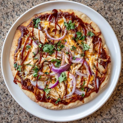 Slice of Chicken BBQ Pizza revealing juicy grilled chicken, red onion rings, and melted cheese atop a smoky barbecue sauce base.