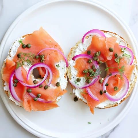 Generously spread Bagel with Cream Cheese, topped with smoked salmon and red onion for a savory bite.