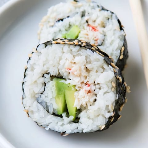 Classic California Roll with creamy avocado, crab, and crisp cucumber served on a platter.