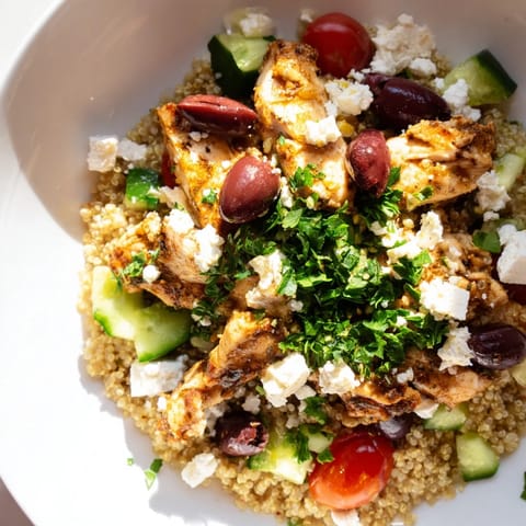 Hearty Mediterranean Chicken Bowl featuring juicy chicken, crisp cucumbers, tangy feta, and chickpeas, served over warm quinoa for a healthy meal.  