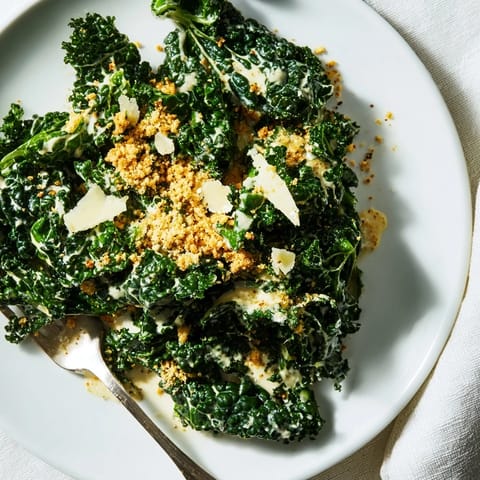 Freshly shaved Parmesan and cracked black pepper garnish this vibrant Garlic Parmesan Kale Salad, perfect as a light lunch or side.  
