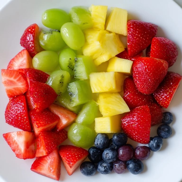 Fruit Salad tossed with orange juice, lemon, and honey, ready to serve as a refreshing vegan dessert.