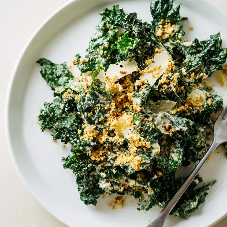 A close-up of a bowl of Garlic Parmesan Kale Salad with glistening dressing, showcasing the salad’s texture and fresh ingredients.